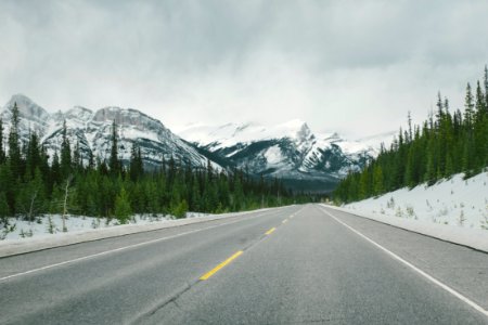 snowy mountains across asphalt road photo