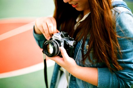 woman holding black bridge camera during daytime photo