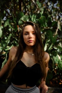 lowlight photography of woman in black crop top near plants