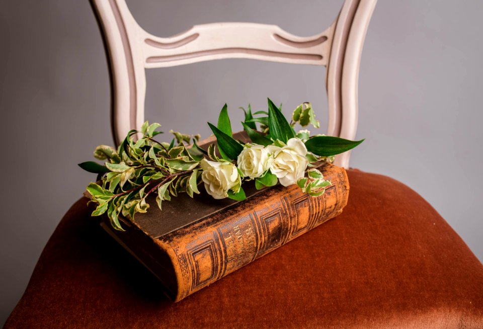 white roses on brown book