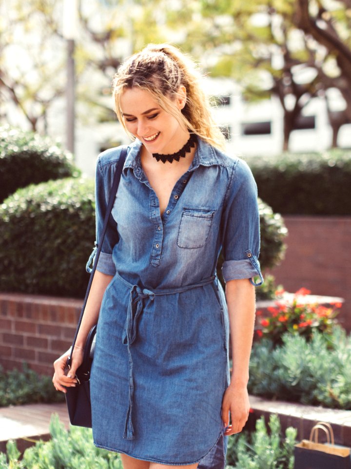 smiling woman wearing blue denim dress