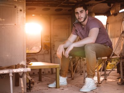 man in gray shirt sitting on brown chair