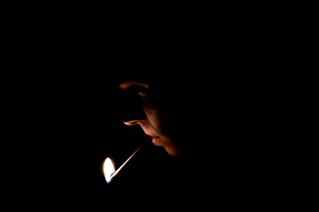 man with lighted matchstick on his mouth photo