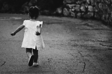 gray scale photography of girl walking towards destination photo