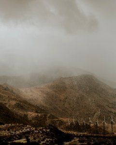 white wind turbines beside mountain