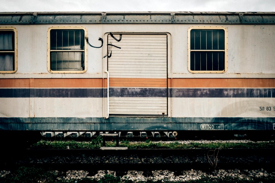 white and orange train on railway