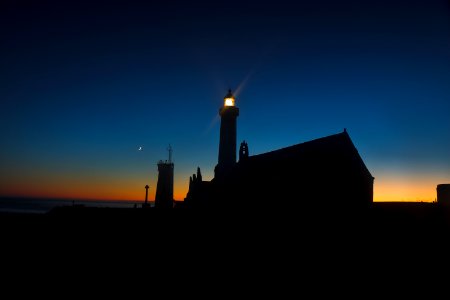silhouette of lighthouse during orange sunset photo