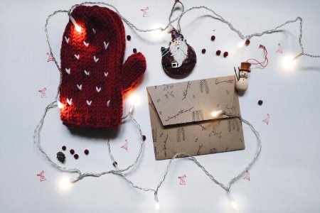 A winter mitt, card envelope and string tree lights. photo