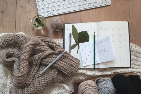 black pencil on white card beside brown knit textile photo