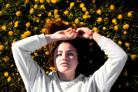 woman in white top laying on flowers photo