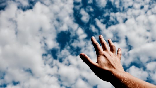 person hand reaching for the sky photo