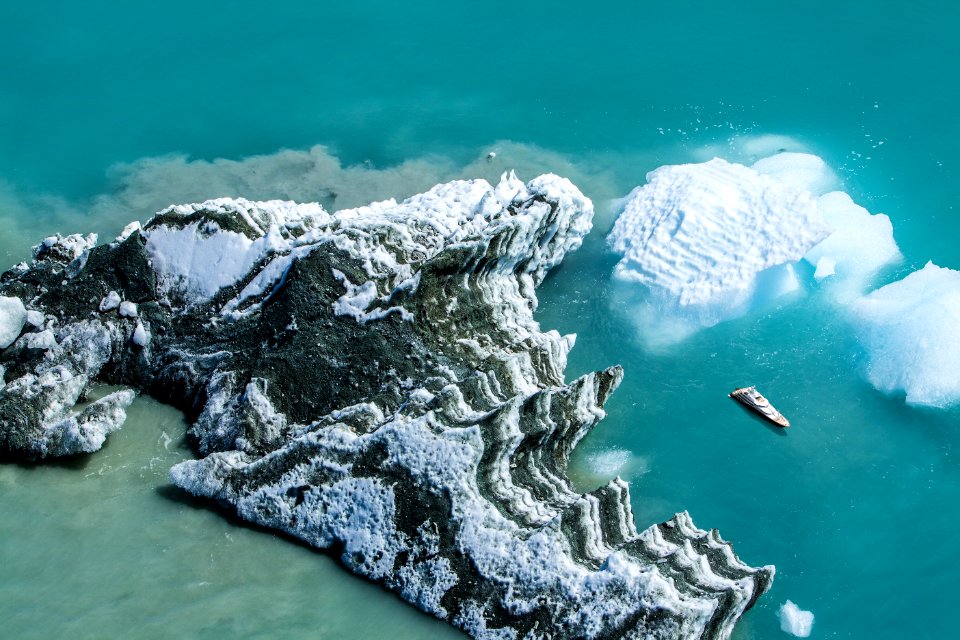white cruise ship passing by white and grey island