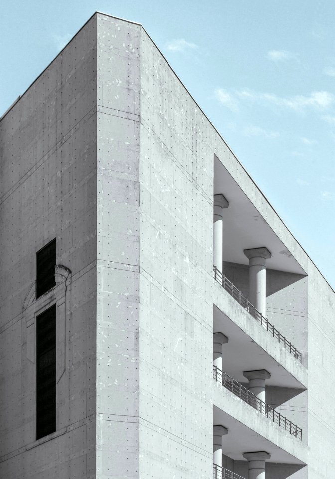 white concrete high rise building under cloudy sky photo