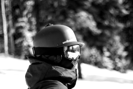 grayscale photography of person standing on snowy mountain photo