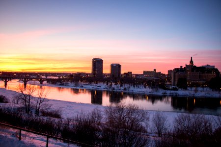 body of water beside cityscape during golden hour photo