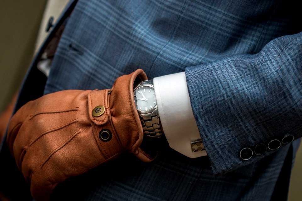 person wearing blue leather gloves with watch