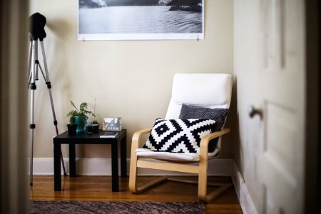 throw pillow on chair beside end table inside room photo