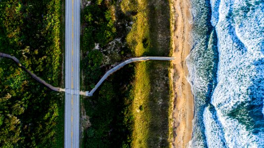 aerial photo of gray roadway near ocean at daytime photo