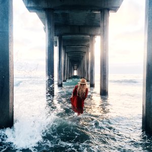 person in red dress in ocean during daytime photo