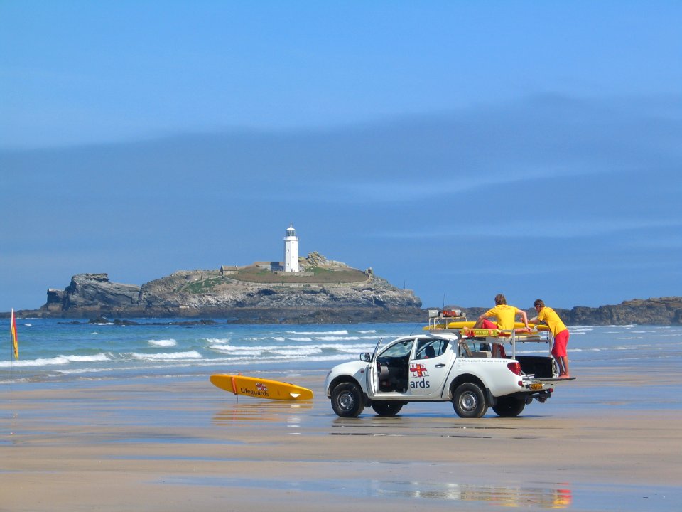 two men in white crew-cab pickup truck on shore