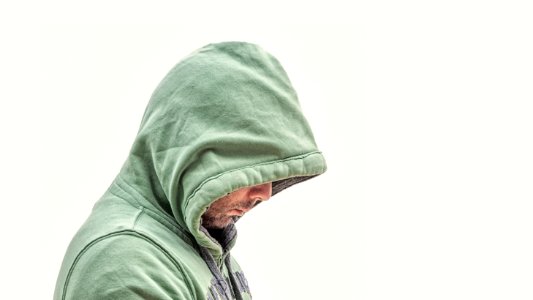 man wearing green hooded jacket with white background photo