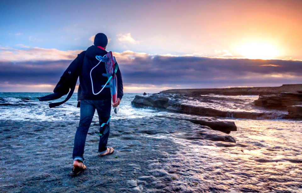 man in blue jeans walking on gray soil
