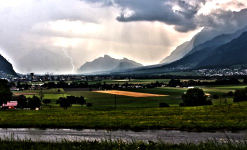 Lightning above the mountains in the surroundings of a small city.