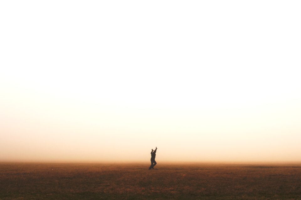silhouette of person raising hands