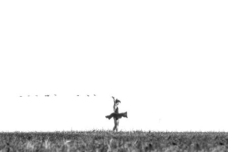 greyscale photo of woman standing on grass field photo