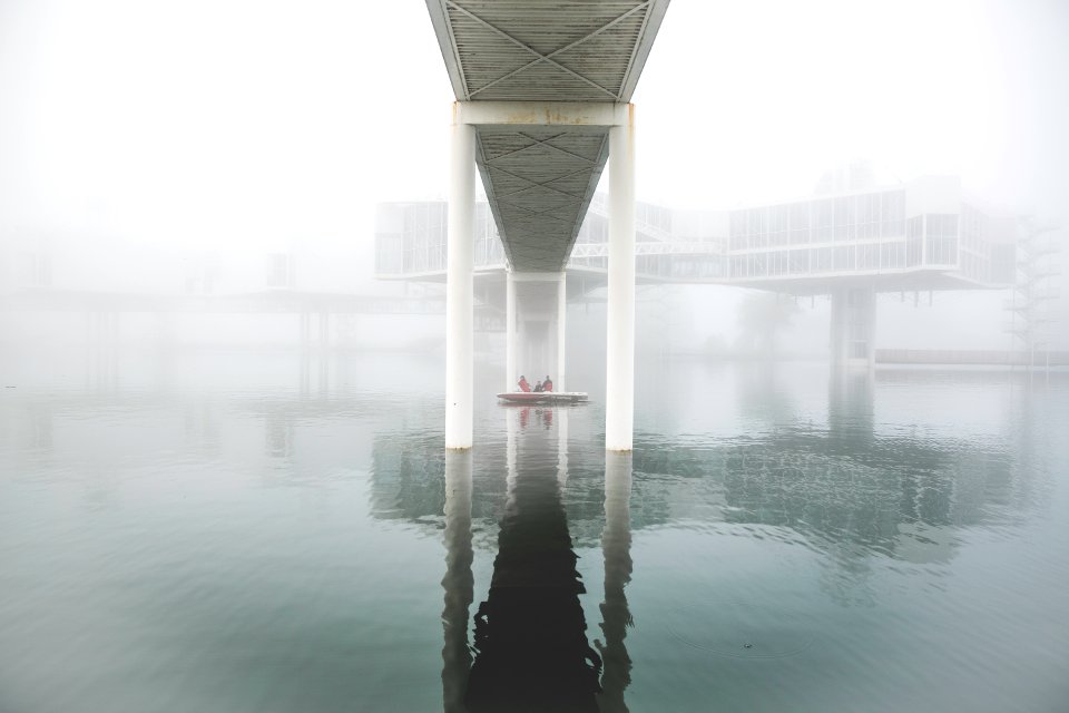 reflection of footbridge above of body of water photo