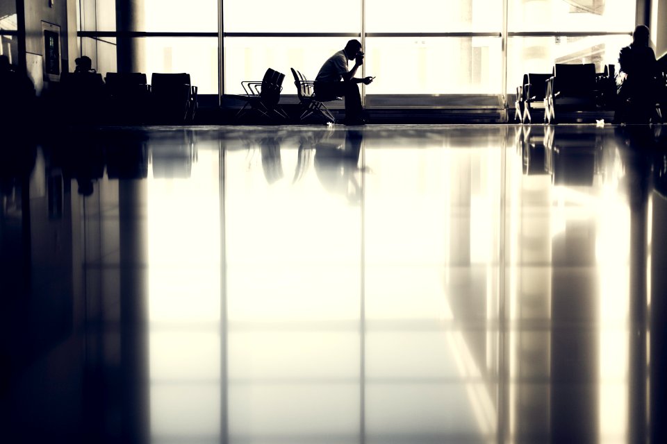 man sitting on chair near glass window