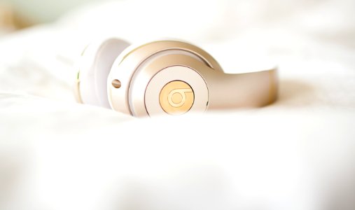 gold edition Beats by Dr.Dre wireless headphones on top of white textile