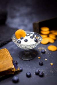 shallow focus photography of yoghurt in glass with blueberries on top photo