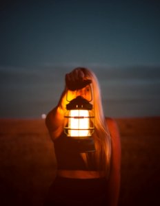 shallow focus photography of woman holding lantern photo
