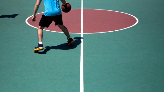 man dribbling ball on court