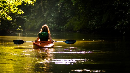 woman on kayak on body of water holding paddle photo