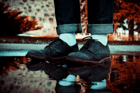 person wearing brown leather shoes stepping on water puddle photo