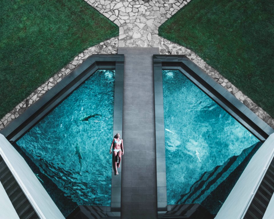 bird's eye view of woman lying on floor beside swimming pool photo