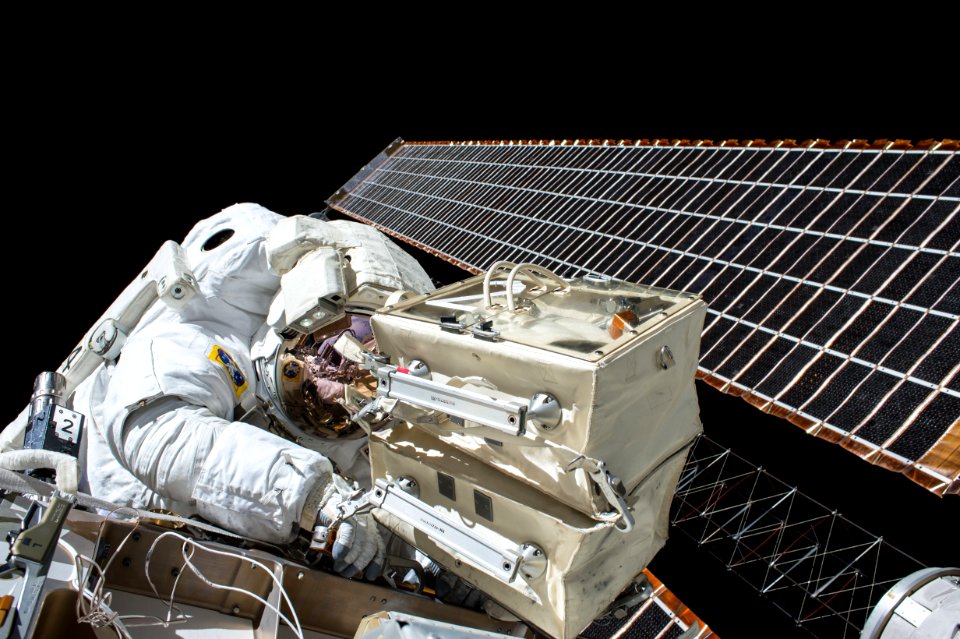 closeup photo of astronaut repairing satellite
