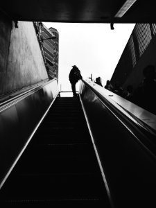 silhouette of person standing beside escalator during daytime photo