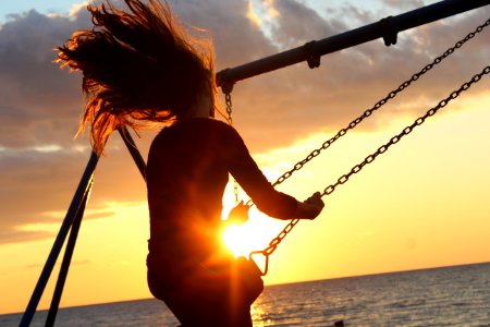 woman riding on swing during sunset photo