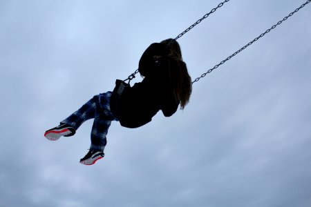 girl swinging during daytime photo