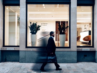 man in black suit jacket in walking gesture photo