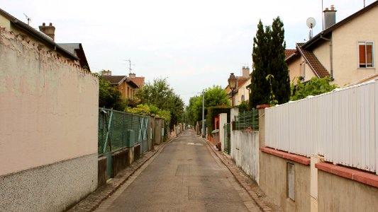gray concrete walkway surrounded by houses during daytime photo