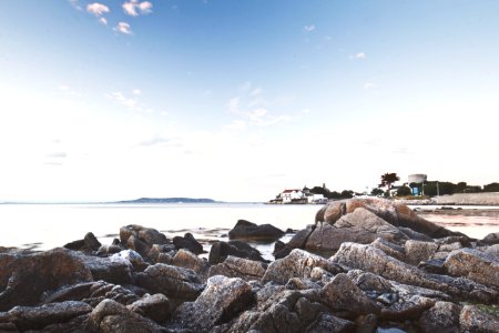 rock formation on seashore under blue sky during daytime