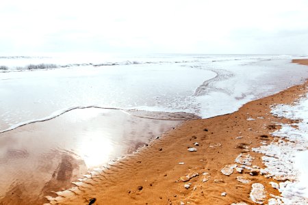 brown sand near body of water during daytime photo