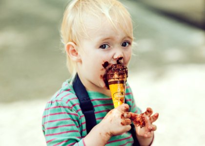 boy in red and white striped polo shirt holding ice cream cone