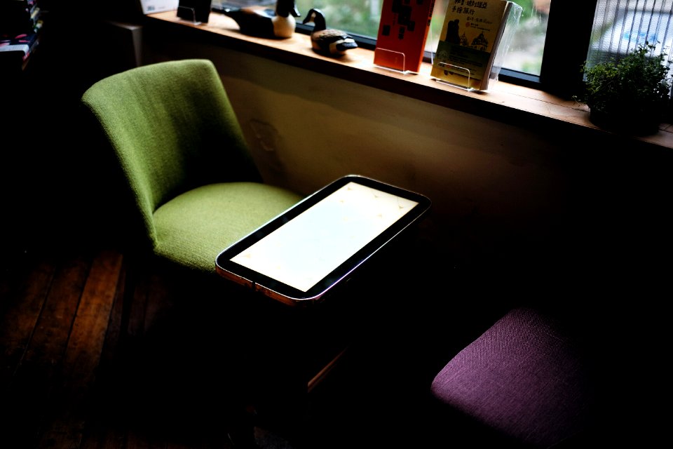 green chair in front of table near window