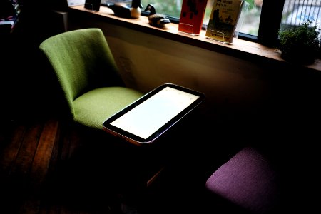 green chair in front of table near window