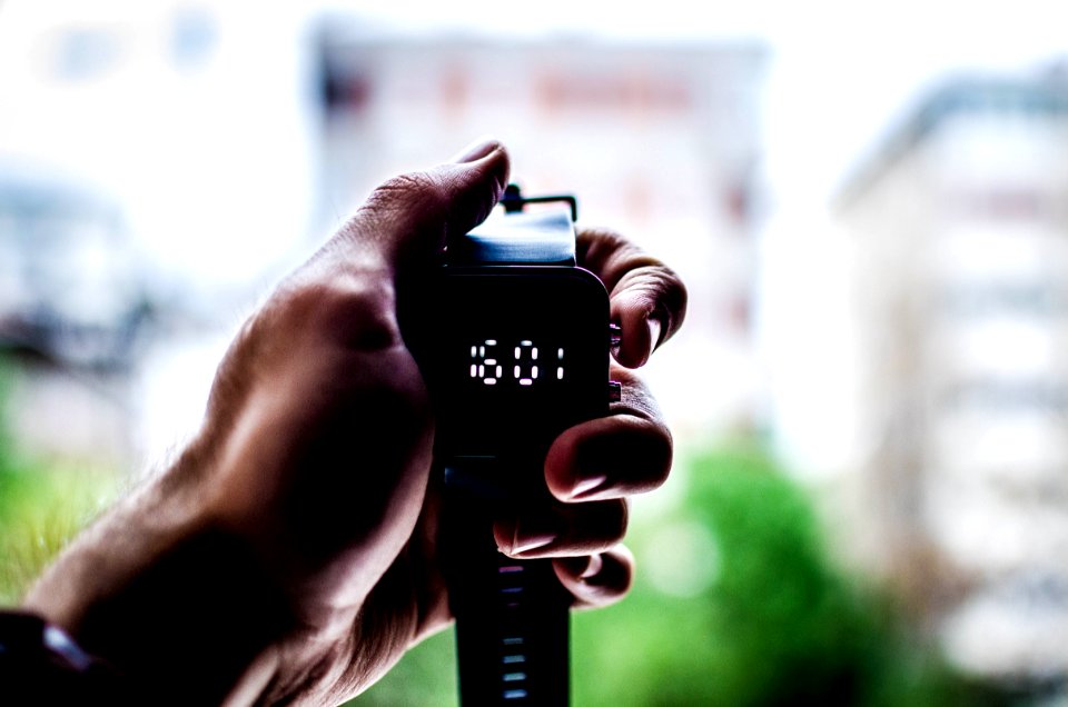 person holding digital watch